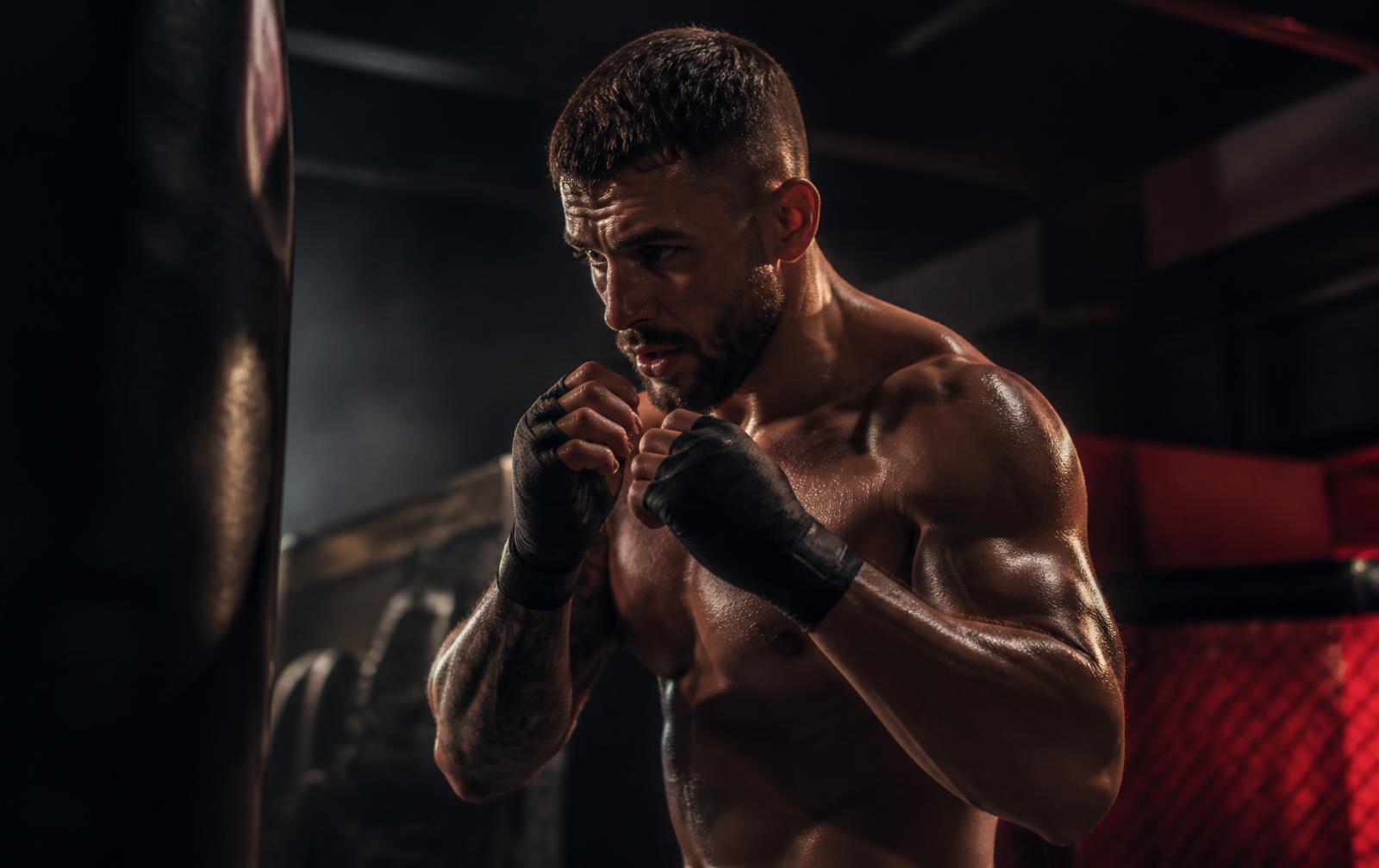 Elitfighter tränar i ett mörkt gym